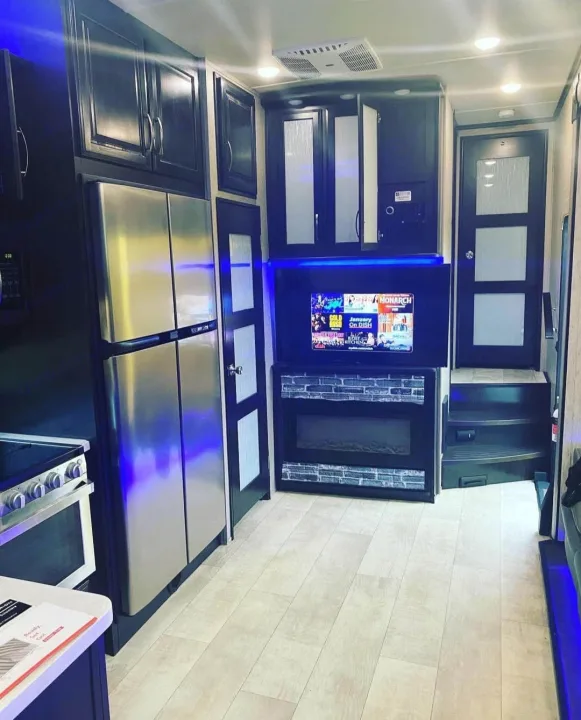 Modern RV rental interior with full kitchen, fridge, TV, fireplace & spacious living area. Perfect for travel.. Grand Design Momentum 2019