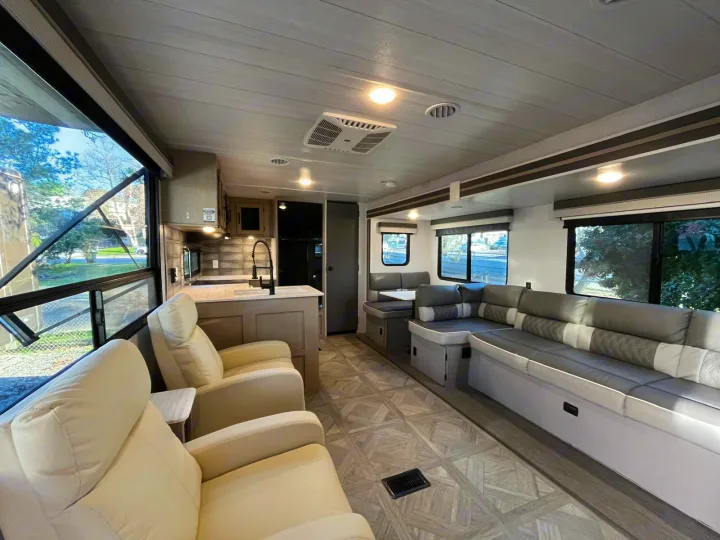 Step inside this inviting RV rental: a bright living space with full kitchen, cozy recliners, and a spacious sofa dinette.. Forest River Salem 2023