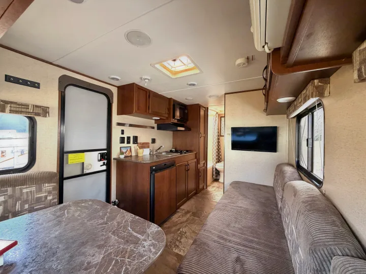 Bright RV rental interior: a fully equipped kitchen, dining area, sofa, and bathroom beyond. Ideal for comfortable travel.. Jayco Jay Flight SLX 2015