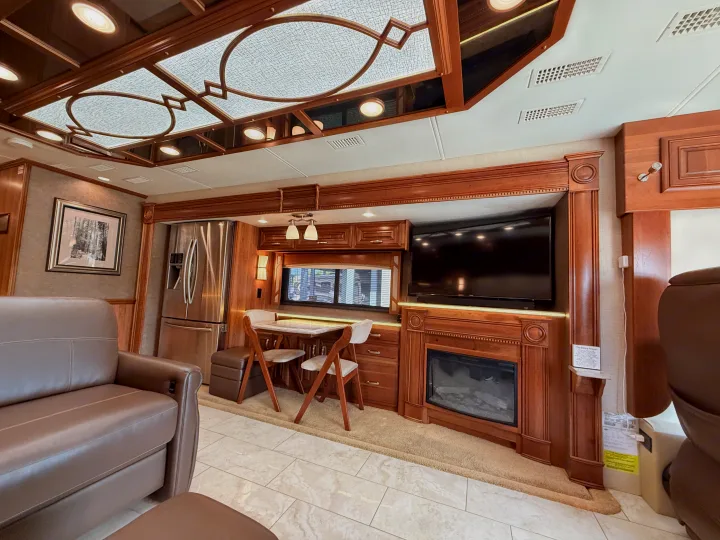Spacious, luxurious RV rental interior featuring a living area, full kitchen, dining nook, entertainment center with TV & fireplace.. Entegra Coach Anthem 2019