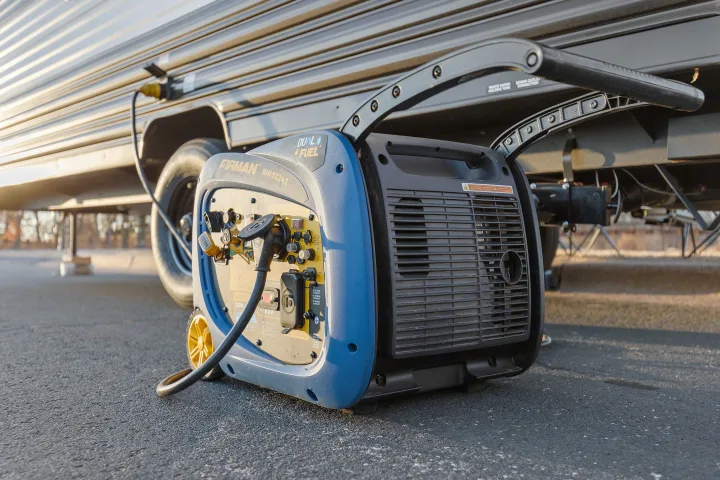 A blue Firman dual-fuel generator is plugged into an RV rental, ready for an off-grid camping experience.. Forest River Wolf Den 16EV 2025