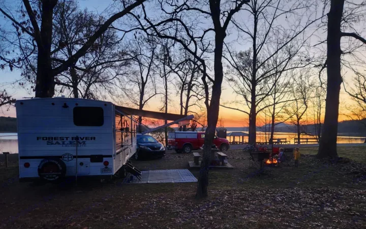 Enjoying a serene RV rental camping trip by the lake at sunset, complete with a cozy campfire and family time in nature.. Forest River Salem Cruise-Lite 2026