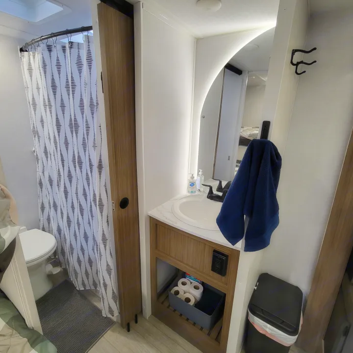 Compact RV rental bathroom with a shower, toilet, and modern vanity featuring a lighted mirror.. Forest River Salem Cruise-Lite 2026
