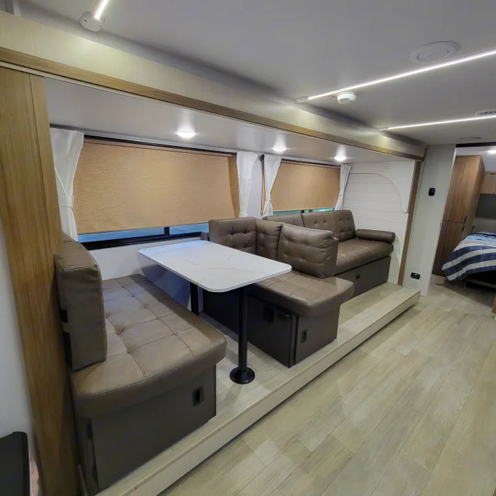 This modern RV rental interior features a dinette, comfortable sofa, and light wood flooring, perfect for travel.. Forest River Salem Cruise-Lite 2026