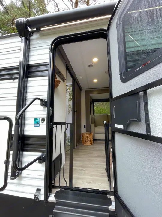 Step into this modern, pet-friendly rv rental, featuring an open entrance, screen door, and welcoming interior.. Grand Design Transcend Xplor 2026