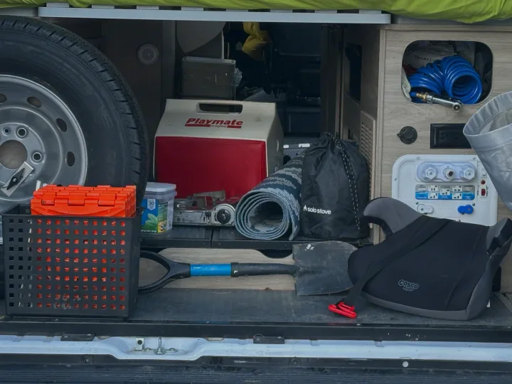RV rental: Packed rear storage with spare tire, cooler, stove, shovel, booster seat, and camping gear for adventure and travel.. Winnebago Solis 2022