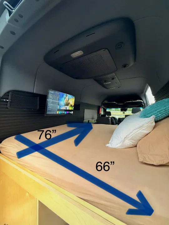 Inside this RV rental, a cozy 76"x66" bed with pillows and a wall-mounted TV provides comfort for your mobile adventure.. Mercedez Benz Sprinter 2023