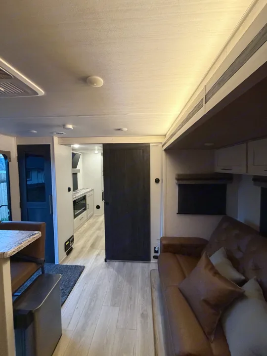 Spacious RV rental interior featuring a cozy living area, modern kitchen, and dining nook with sleek finishes.. Forest River Surveyor Land Surveyor 2024