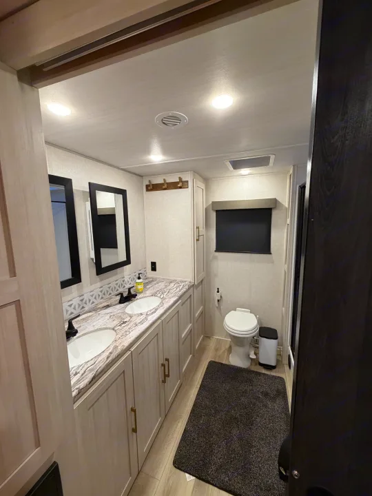 RV rental: Modern bathroom featuring a dual sink vanity, sleek black faucets, and toilet, with a light design.. Forest River Surveyor Land Surveyor 2024