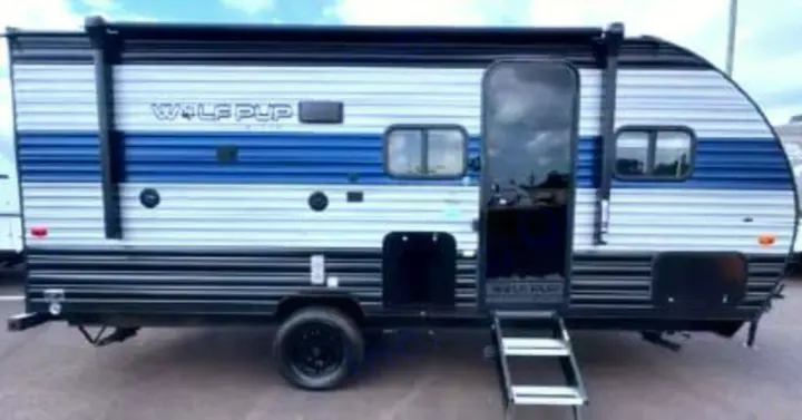 Experience camping with this blue & white Wolf Pup travel trailer rv rental. Features open door, steps & awning.. Forest River Cherokee Wolf Pup Black Label 2021