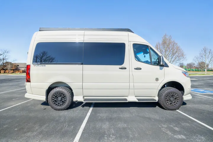 A sleek, light-colored VCRUISE camper van, perfect as an rv rental for your next adventure or road trip.. OGV Luxury Coach V-Cruise 2026