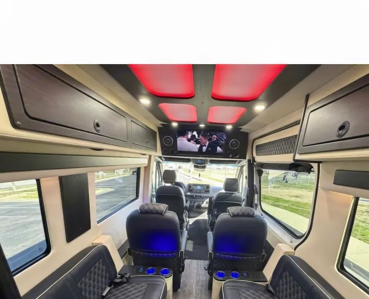 Luxury RV rental interior featuring plush seating, overhead TV, red LED lighting, and custom storage for a premium travel experience.. OGV Luxury Coach V-Cruise 2026