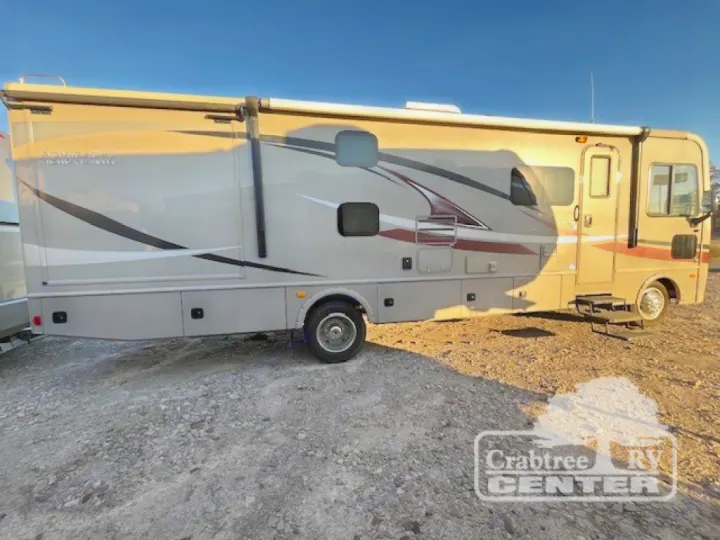 Experience travel with this tan Class A motorhome for rv rental, featuring sleek stripe decals, parked on a gravel lot.. Holiday Rambler Admiral 2017