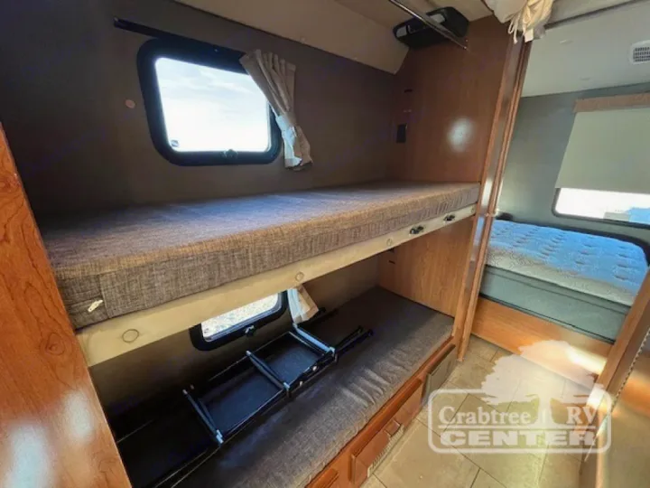 This RV rental offers a spacious sleeping area with twin bunk beds, windows, and an adjacent main bed.. Holiday Rambler Admiral 2017