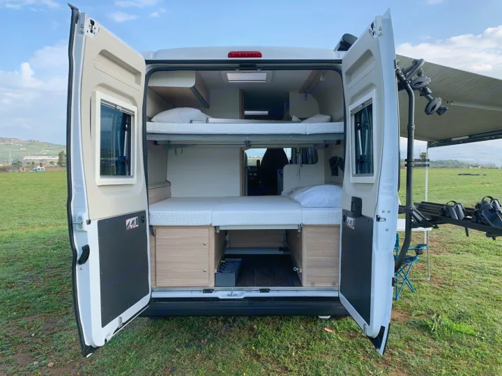Explore this spacious **rv rental** with bunk beds! Rear doors open to reveal a comfortable interior, bike rack, and extended awning.. Sunlight Cliff 600 2023