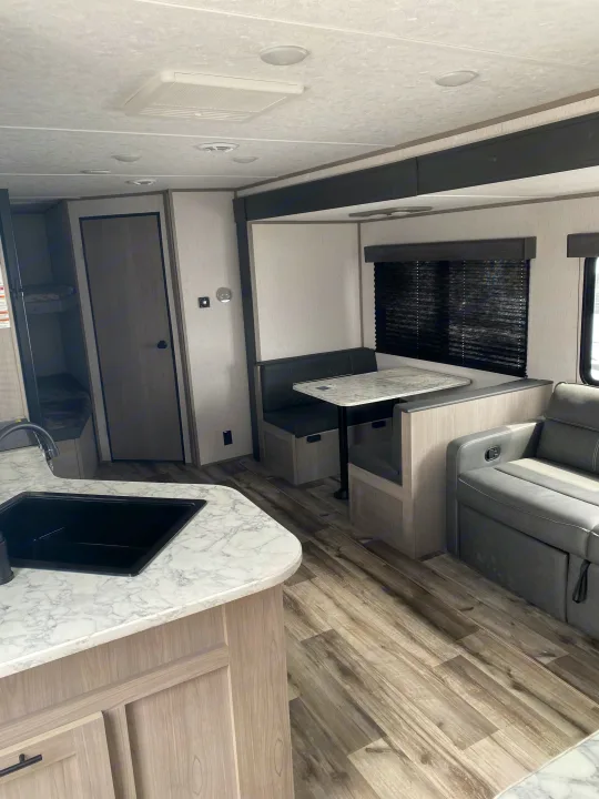 RV rental interior: kitchen, dinette, sofa, & bunk beds. A comfortable and functional space for your travel adventures.. Dutchmen Coleman Lantern LT 2023