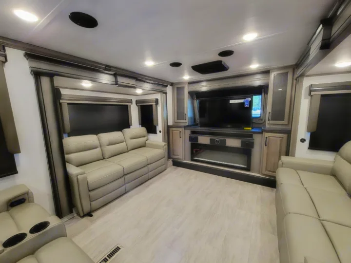 Spacious, modern RV rental living area with comfortable sofas, a large TV, and fireplace for a cozy experience.. Keystone RV Montana Legacy 3761 FL 2023