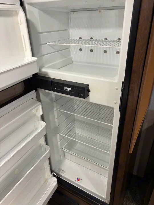 Empty Norcold RV refrigerator interior, with freezer and fridge shelves, perfect for your rv rental. Clean and ready for use.. KZ Escape 2018