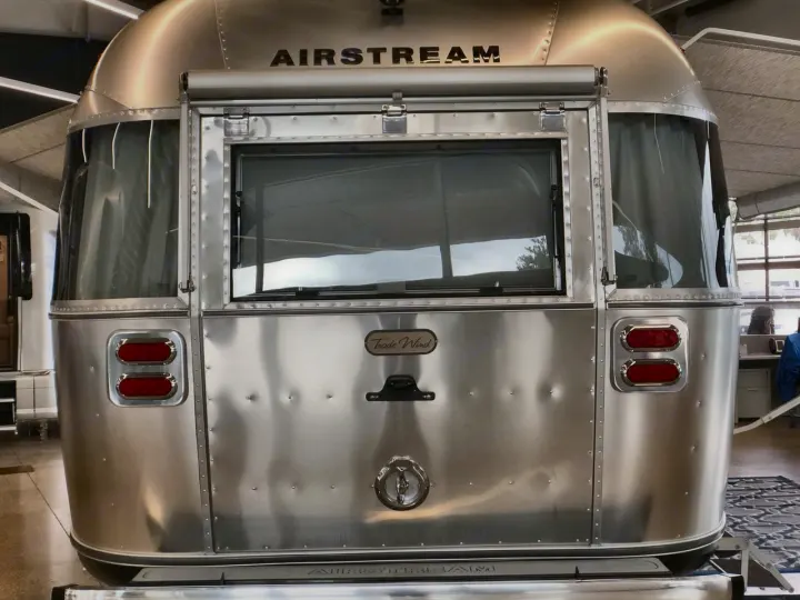 Iconic Airstream travel trailer, with its shiny, riveted rear and classic windows, perfect for an RV rental adventure.. Airstream Trade Wind 2025