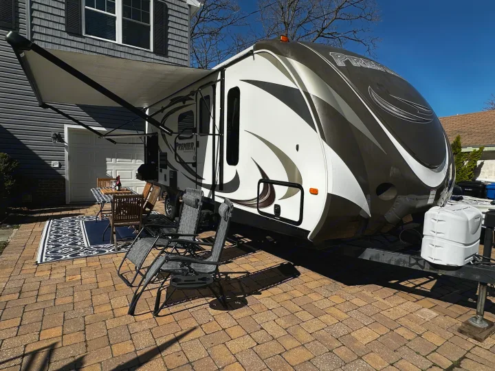 This RV rental is set up for outdoor living with an awning, table, and chairs on a brick patio. Great for camping trips.. Keystone RV Bullet Premier 2015
