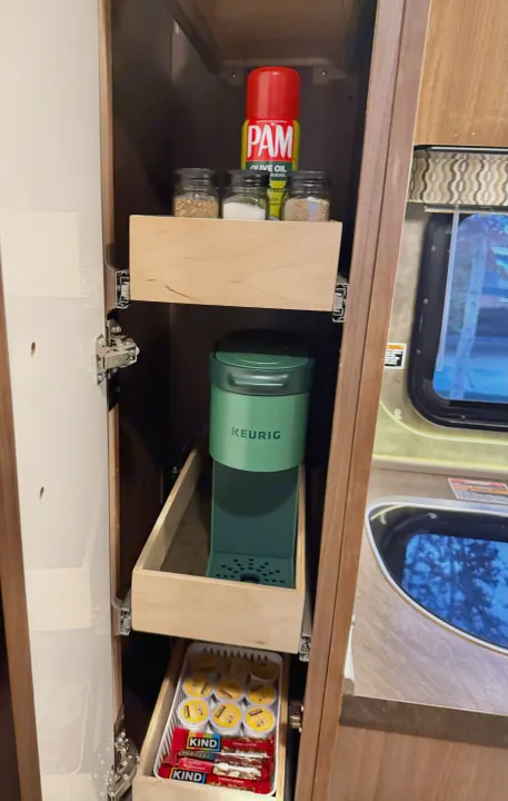 Efficient RV rental kitchen storage: Keurig, spices, and snacks neatly organized in convenient pull-out drawers.. Winnebago Trend 2015