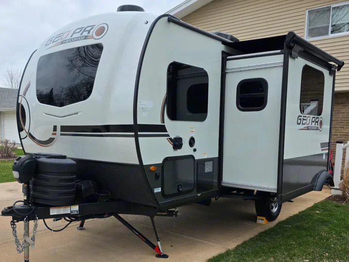 This white and gray Rockwood Geo Pro travel trailer, shown with its slide-out extended, is ready as an RV rental.. Forest River Rockwood Geo Pro 2025