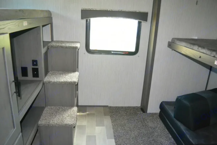 RV rental bunk room: built-in carpeted steps to bunks, a window, and extra sleeping space for family travel comfort.. Cruiser RV MPG Ultra Lite 2021