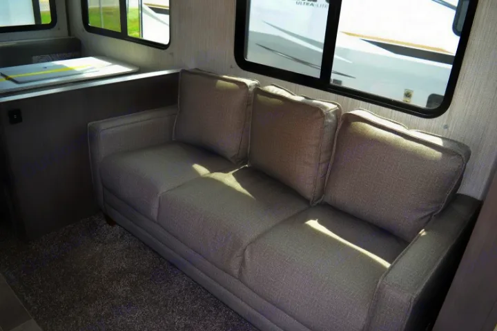 Cozy gray sofa and dinette in a modern RV rental interior, perfect for relaxing during your trip.. Cruiser RV MPG Ultra Lite 2021