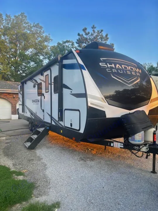 Explore with this Shadow Cruiser travel trailer rv rental. The white & black unit is parked on gravel, steps down.. Cruiser RV Shadow Cruiser 2020