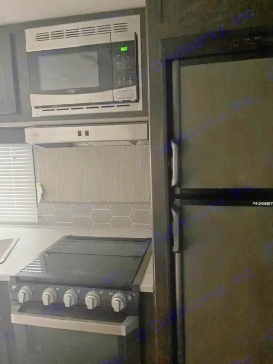 RV rental kitchen: This compact space features a microwave, stovetop, Dometic fridge, and stylish hexagonal backsplash.. Cruiser RV Shadow Cruiser 2020