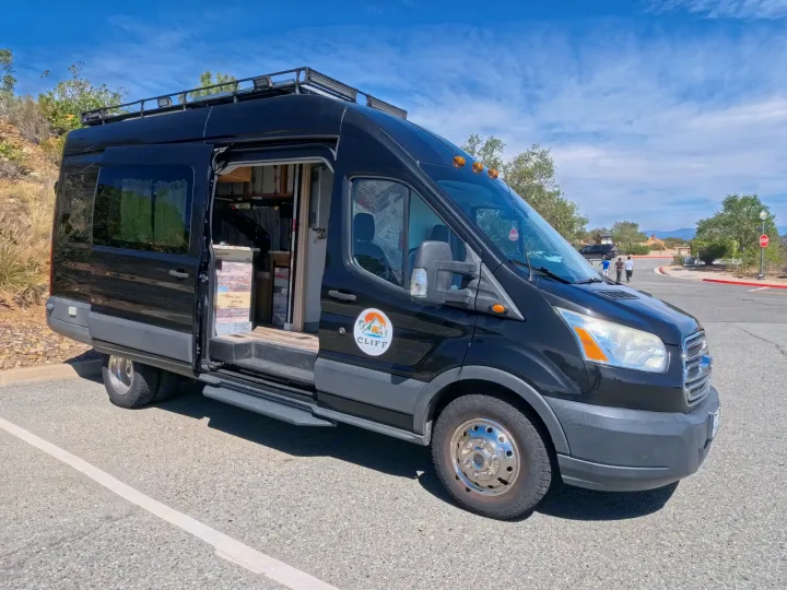 CLIFF RV rental: a black Ford Transit camper van with custom interior shown through its open side door, parked outdoors.. Ford Transit Custom 2015