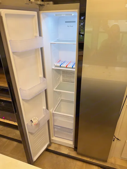 Open, empty rv rental fridge and freezer with cow shaker. Digital display shows 38°F/0°F and LED light illuminates 'No Frost'.. Forest River Coachman Chaparral 2025