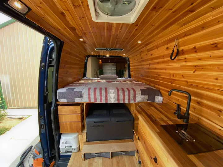 RV rental ready: Beautifully crafted camper van interior with wood paneling, bed, kitchen, Dometic fridge, and toilet.. Mercedes-benz 4x4 Sprinter mwb 2019