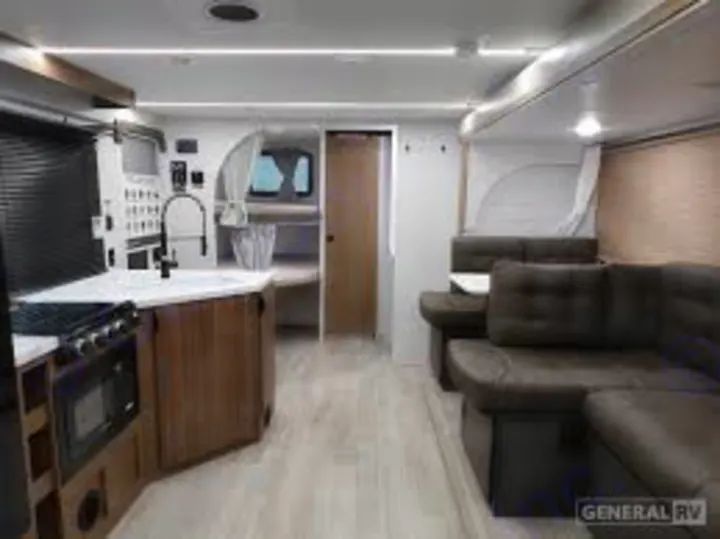 This spacious, modern RV rental interior features a full kitchen, comfortable living area, and rear bunk beds.. Forest River Wildwood X-Lite 2025