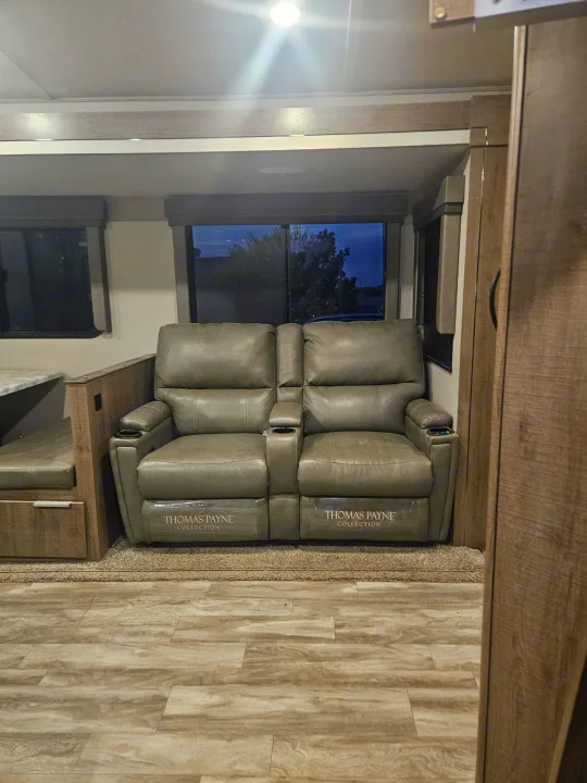 View inside an RV rental showing two plush recliners with cup holders & charging ports, next to a dinette and windows.. Imagine Imagine design 2020
