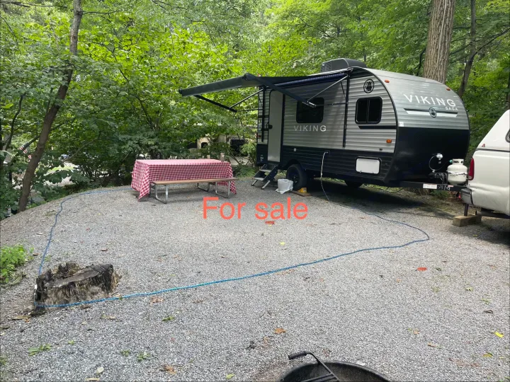 Viking Saga travel trailer (RV) for sale at a shaded gravel campsite with picnic table & trees. Ideal for an rv rental.. Other 1906st Saga 2021