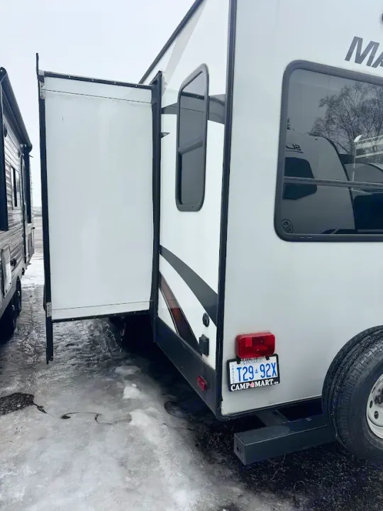 RV rental with extended slide-out, parked on a snowy lot. An Ontario plate is visible on the rear.. Heartland RVs Mallard 2019