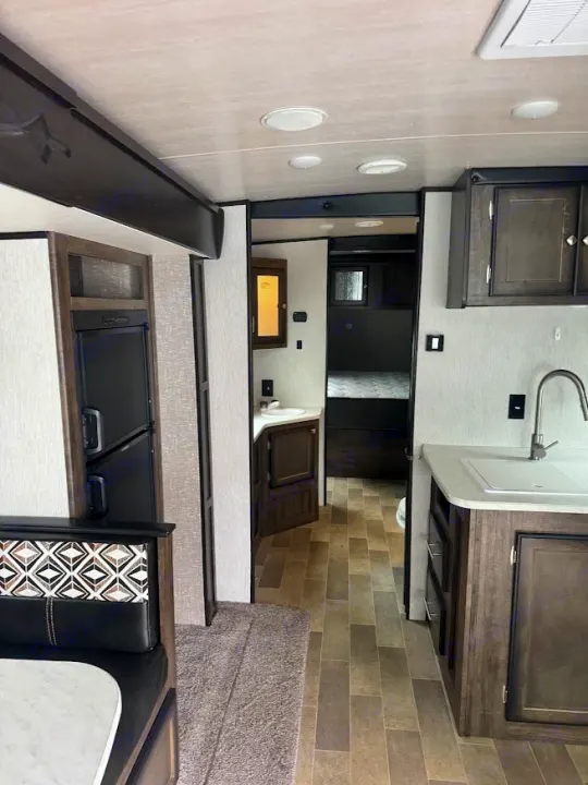 Rv rental interior: a modern camper showcasing its kitchen, dinette, bathroom vanity, and bedroom layout.. Heartland RVs Mallard 2019