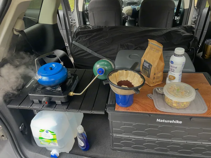Enjoying an RV rental adventure! Car trunk setup with a steaming kettle, coffee brewing station, and a ready meal.. Dodge Journey 2017