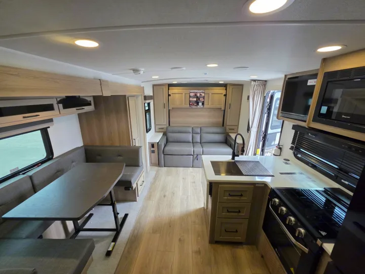 Bright, modern rv rental interior: dinette, full kitchen with stove/oven, and convertible sofa bed. Modern and spacious.. Forest River Rockwood Mini Lite 2024