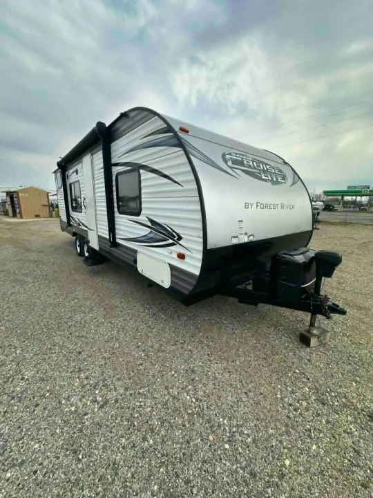 Explore with this white & black Salem Cruise Lite travel trailer, a great option for an RV rental, parked on gravel.. Forest River Salem Cruise Lite 2016