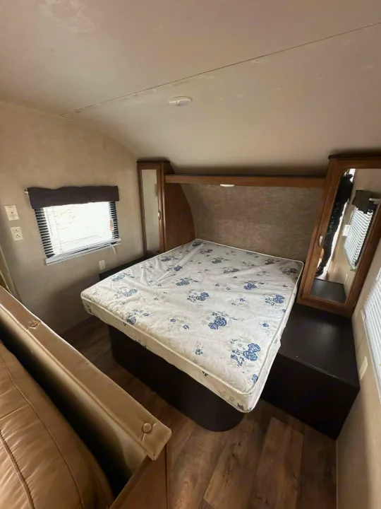 This RV rental bedroom features a comfortable bed, window, and mirrored wardrobe, perfect for your next adventure.. Forest River Salem Cruise Lite 2016