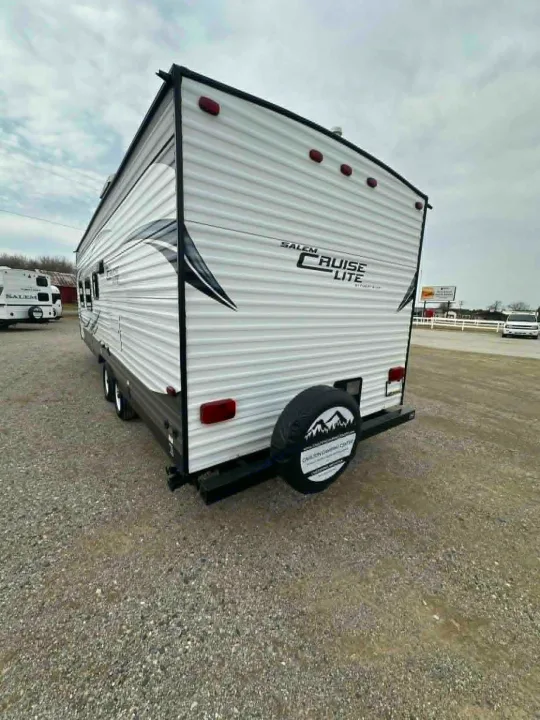 White Salem Cruise Lite travel trailer, an excellent option for an rv rental, viewed from the rear on a gravel lot.. Forest River Salem Cruise Lite 2016