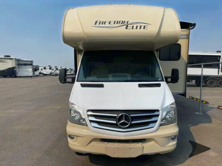 Front view of a Freedom Elite Class C RV, built on a Mercedes-Benz chassis, available for rv rental, parked in a lot.. Thor Freedom Elite 2018