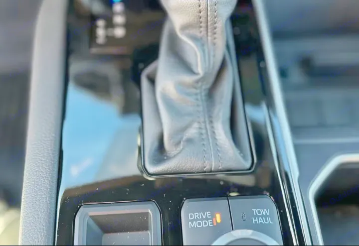 Inside a vehicle: gear shifter, illuminated DRIVE MODE, & TOW HAUL buttons. Essential controls for your RV rental journey.. Toyota Tundra TRD Off Road 2026