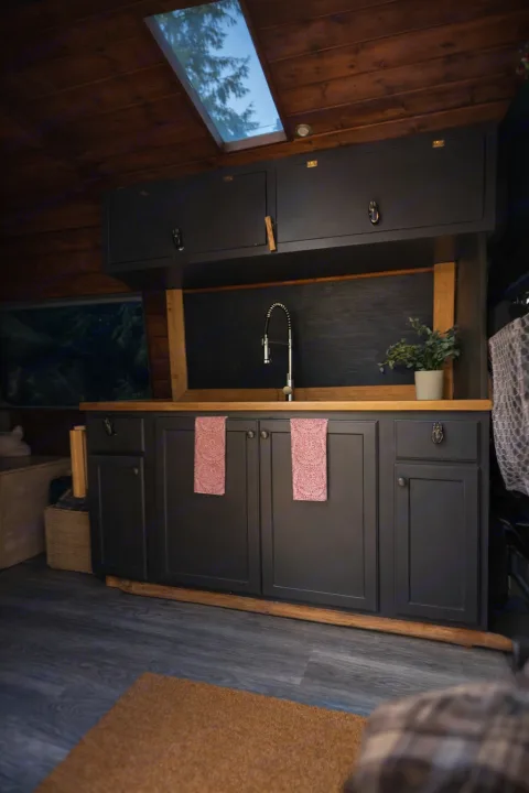 Cozy RV rental kitchen interior with dark cabinets, wood countertop, sink, and skylight. Perfect for your next adventure.. Mercedes Sprinter 2008