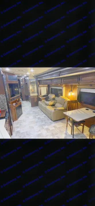 RV rental living space with a tan sofa, dining set, entertainment center, and tiled floor for comfort.. Fleetwood Bounder 2013