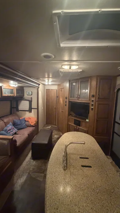 Cozy RV rental interior featuring a living area with a couch, kitchen island, and entertainment center for comfort.. Crossroads RV Rezerve 2015