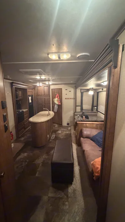 Spacious RV rental interior showcasing a kitchen island, dining booth, and cozy sofa—your home away from home.. Crossroads RV Rezerve 2015