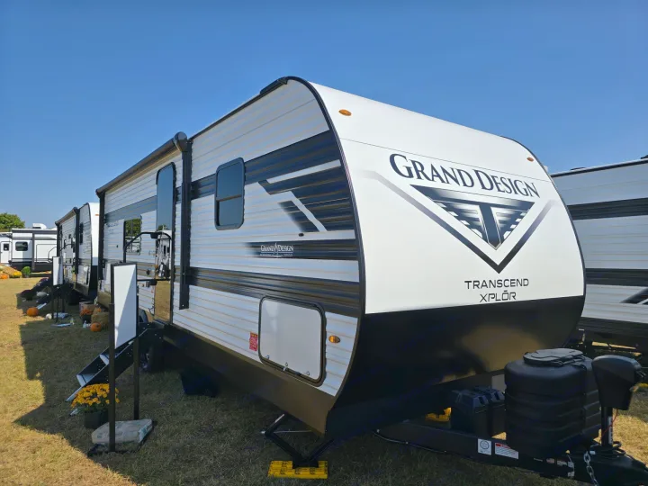 Front and side view of a white and black Grand Design Transcend Xplor travel trailer, ideal for rv rental road trips.. Grand Design Transcend Xplor 2026